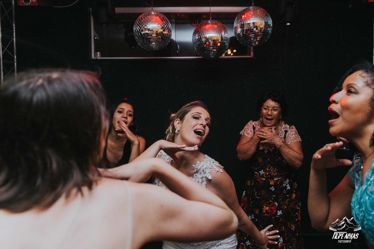 Noiva dançando anita na sua festa de casamento junto com as amigas