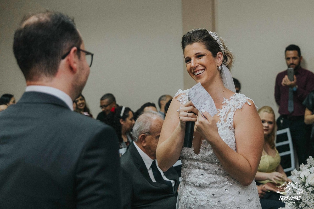 noiva sorri durante a leitura dos votos para o noivo