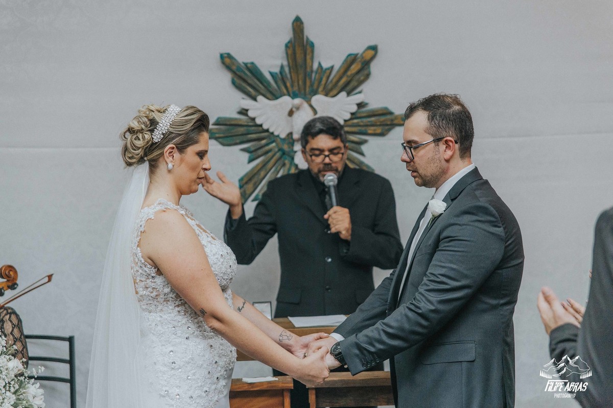 noivos sendo abençoados pelo pastor