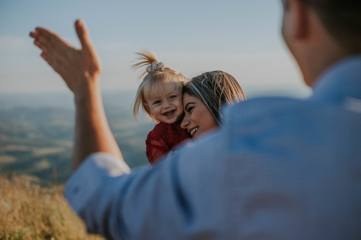 fotografia espontânea de familia em que a mãe está abraçando a filha e sorrindo