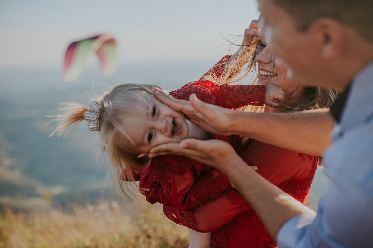pais brincando com a filha durante um ensaio fotografico de familia no topo do mundo minas gerais
