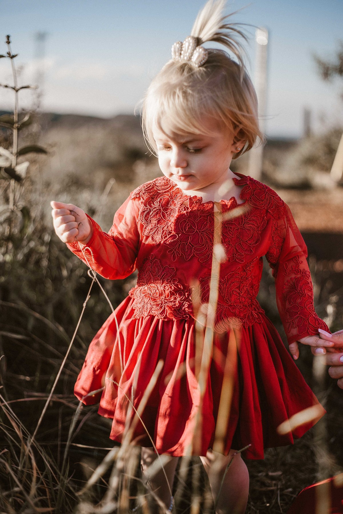 retratos infantis em que a bebe está brincando com matinho