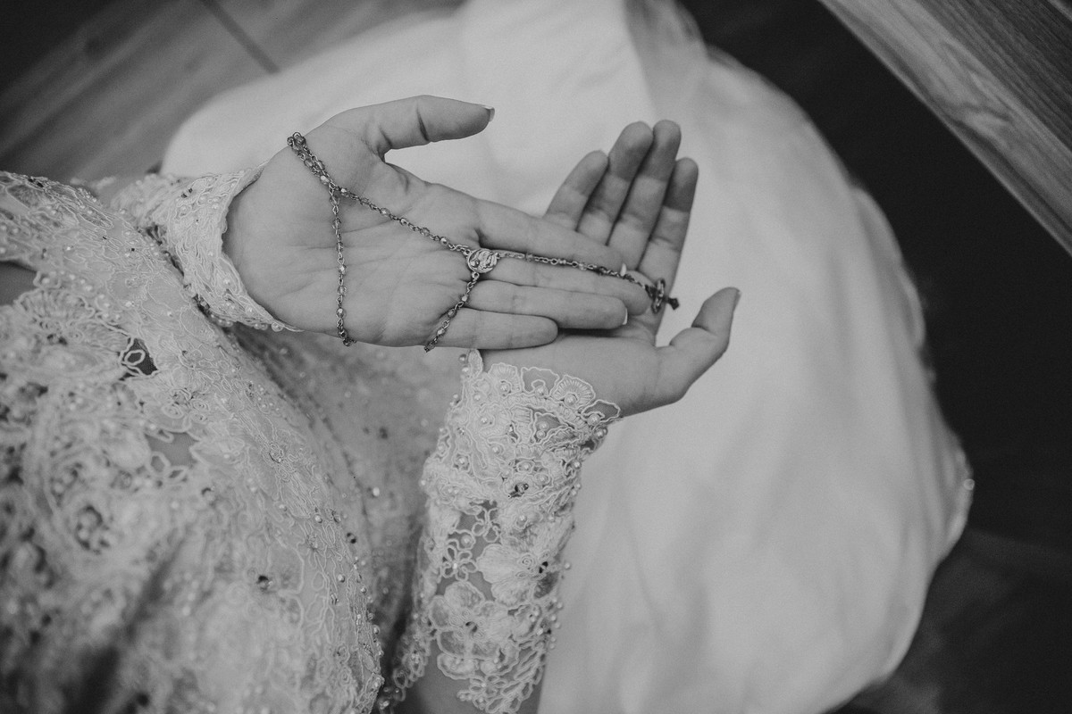 detalhes do terço nas mãos da noiva que será usado na cerimônia de casamento em belo horizonte
