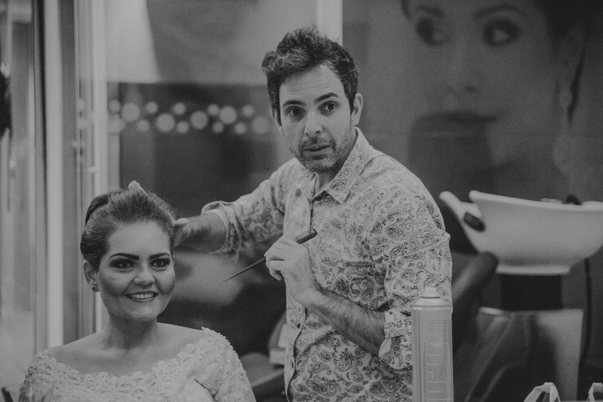 noiva sorrindo enquanto o Gracciano finaliza seu penteado de noiva