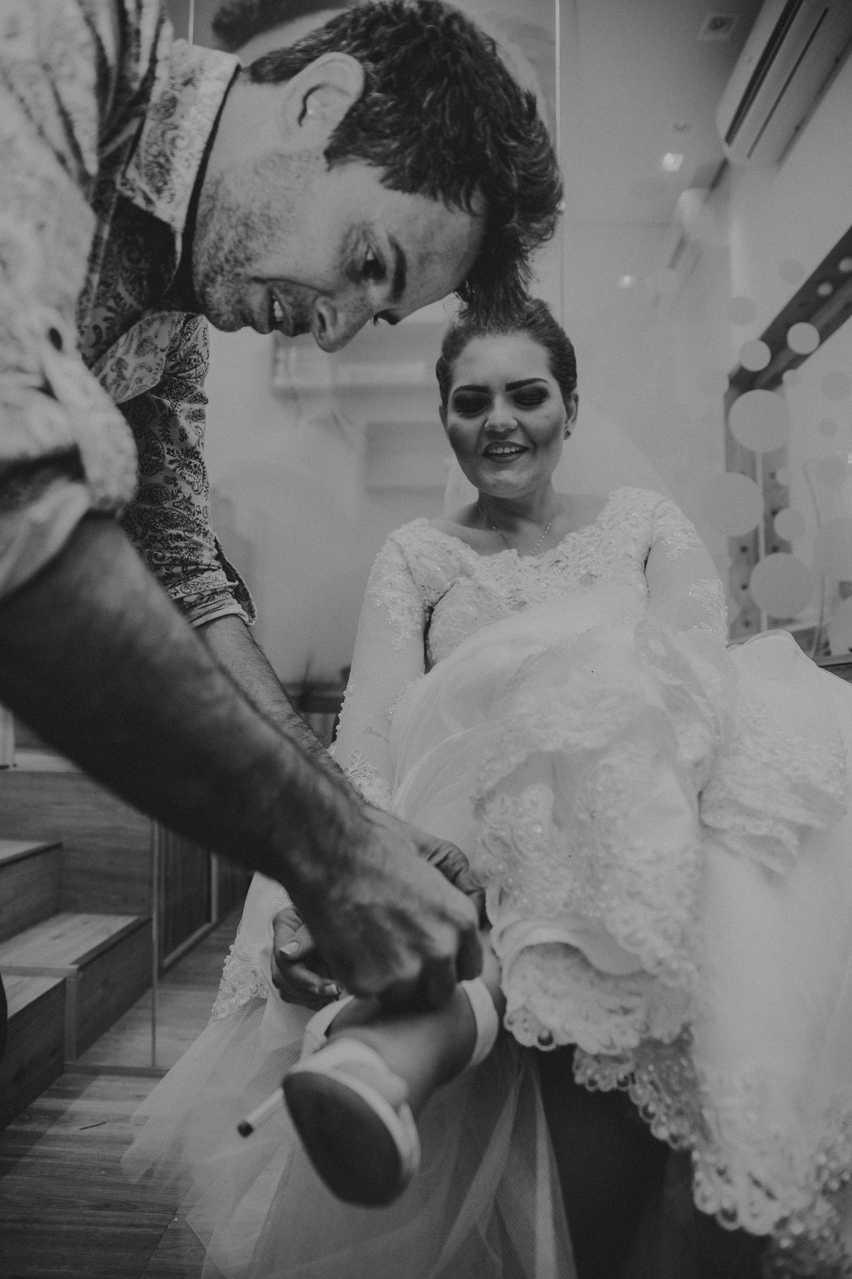 Cabeleileiro ajudando a noiva a colocar o sapato para a sua cerimonia de casamento em Belo Horizonte