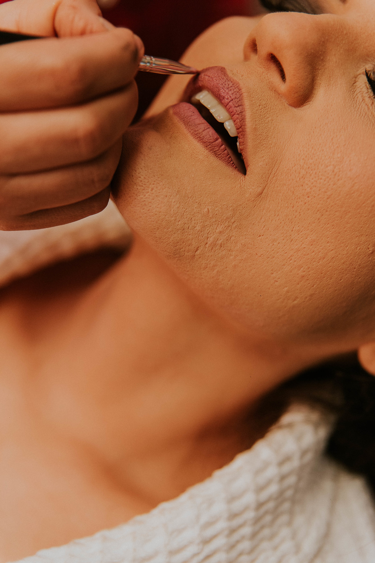 Detalhes da boca da noiva finalizando o batom