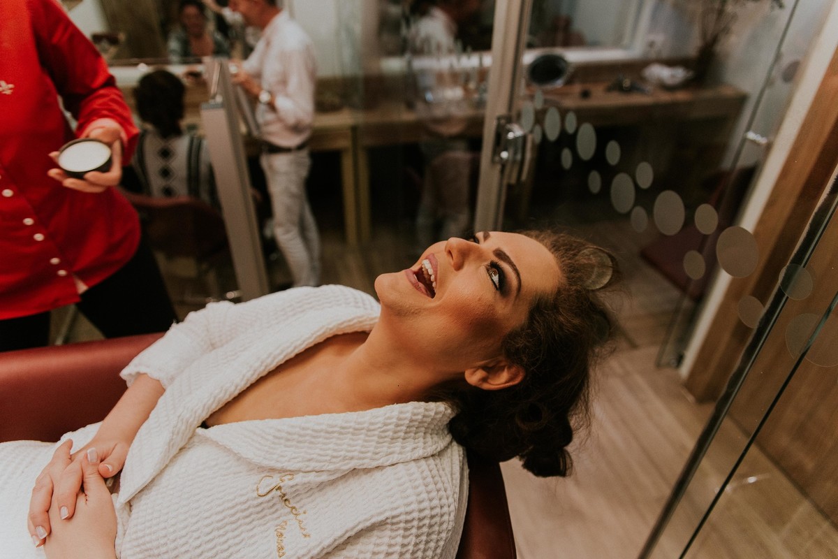 Noiva sorrindo e se divertindo de roupão durante o making of