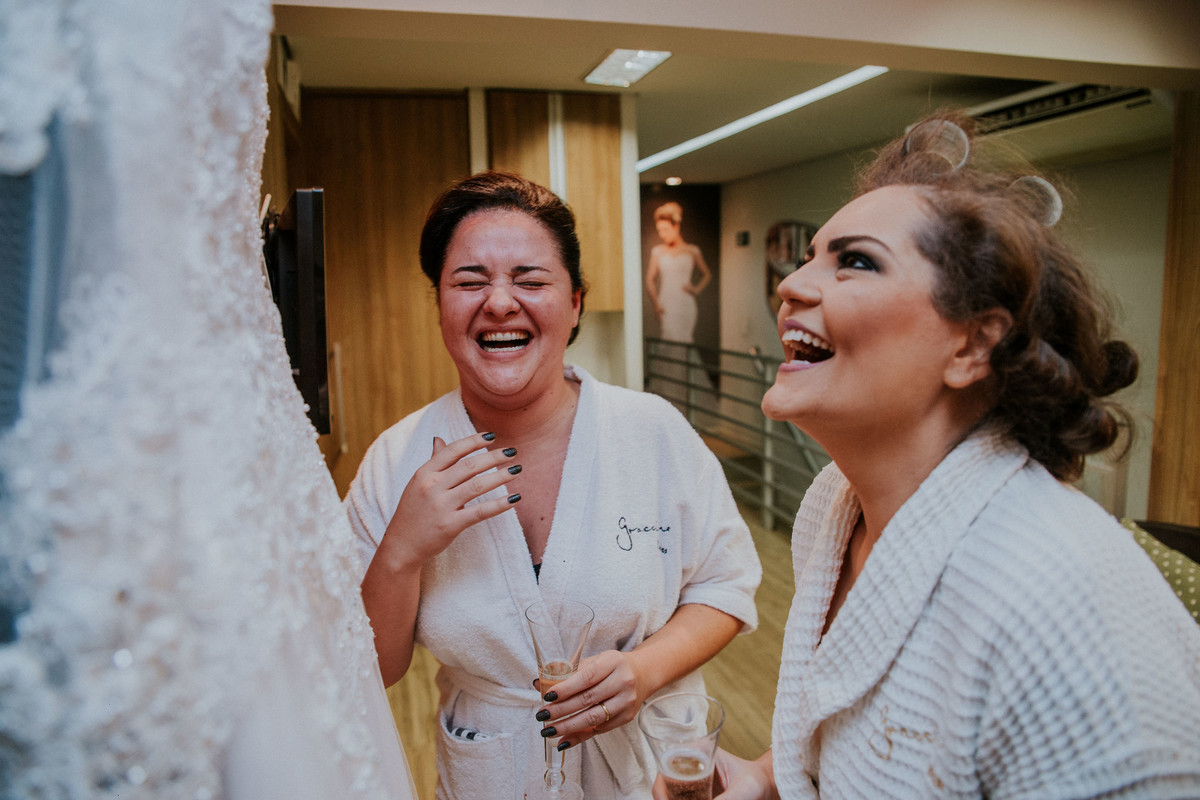 noiva e madrinha sorrindo durante o seu making of para o casamento