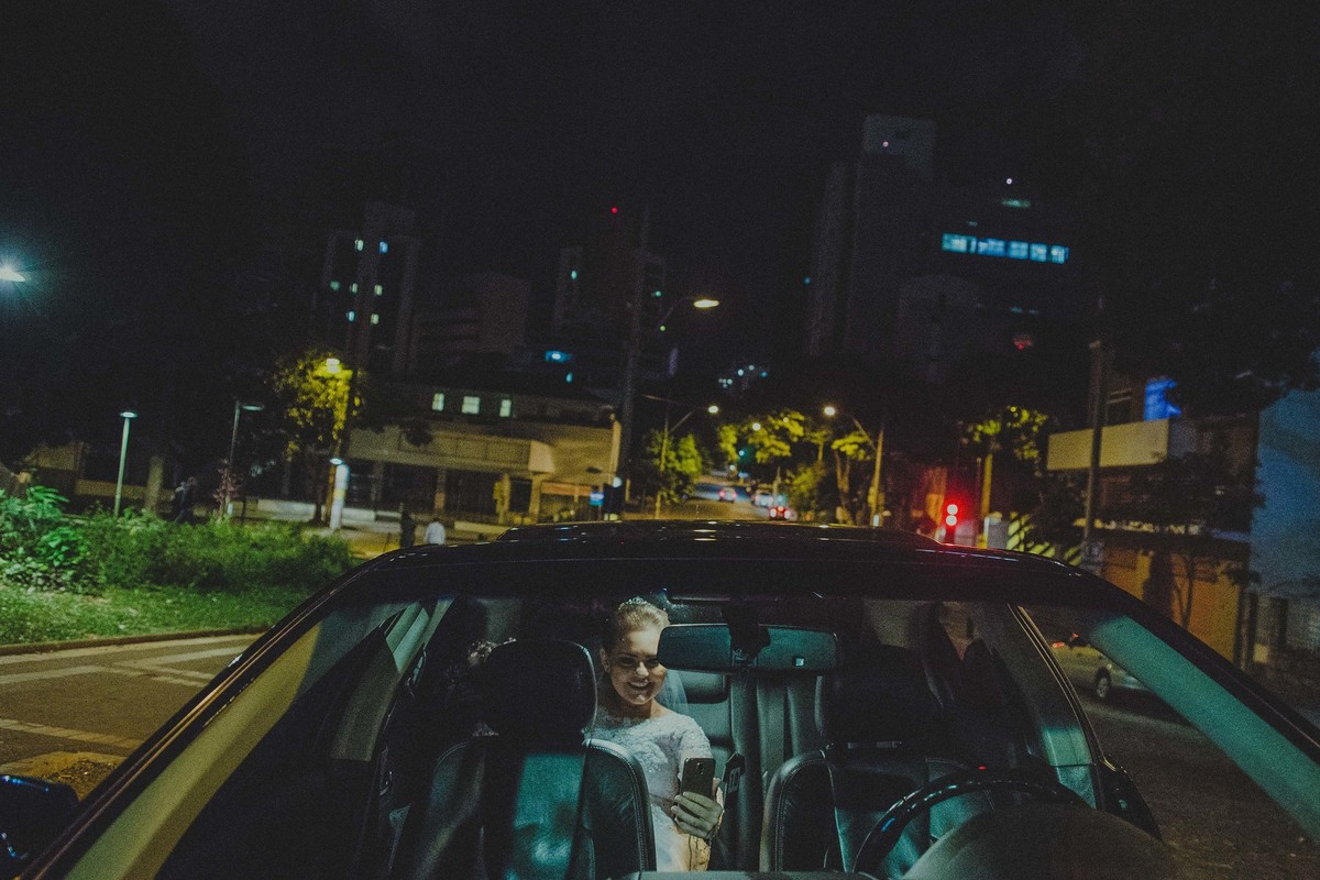 Noiva tirando selfie dentro do carro enquanto espera para entrar na igreja no seu casamento na igreja da boa viagem em belo horizonte