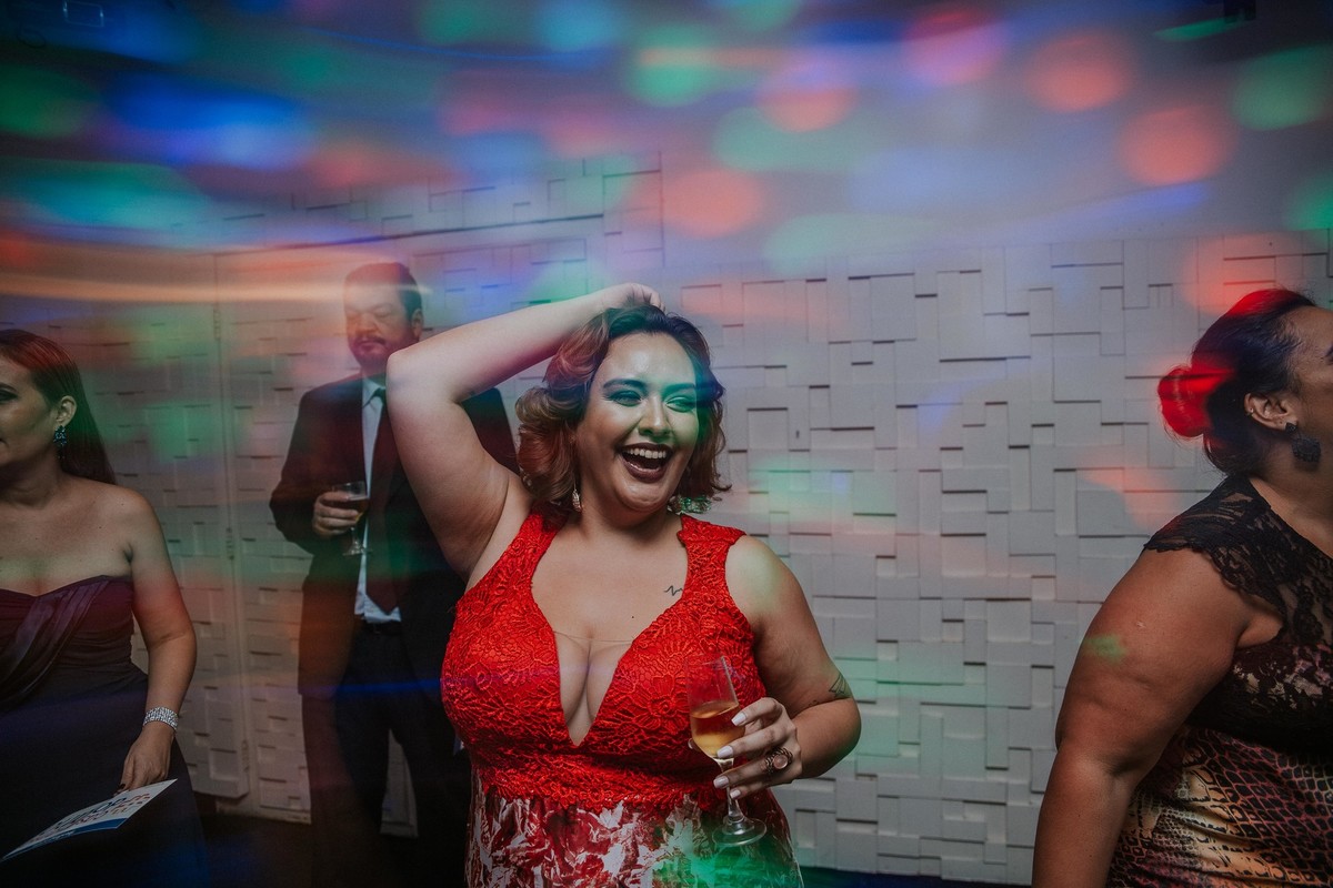recepção de casamento em que a amiga da noiva está sorrindo e dançando