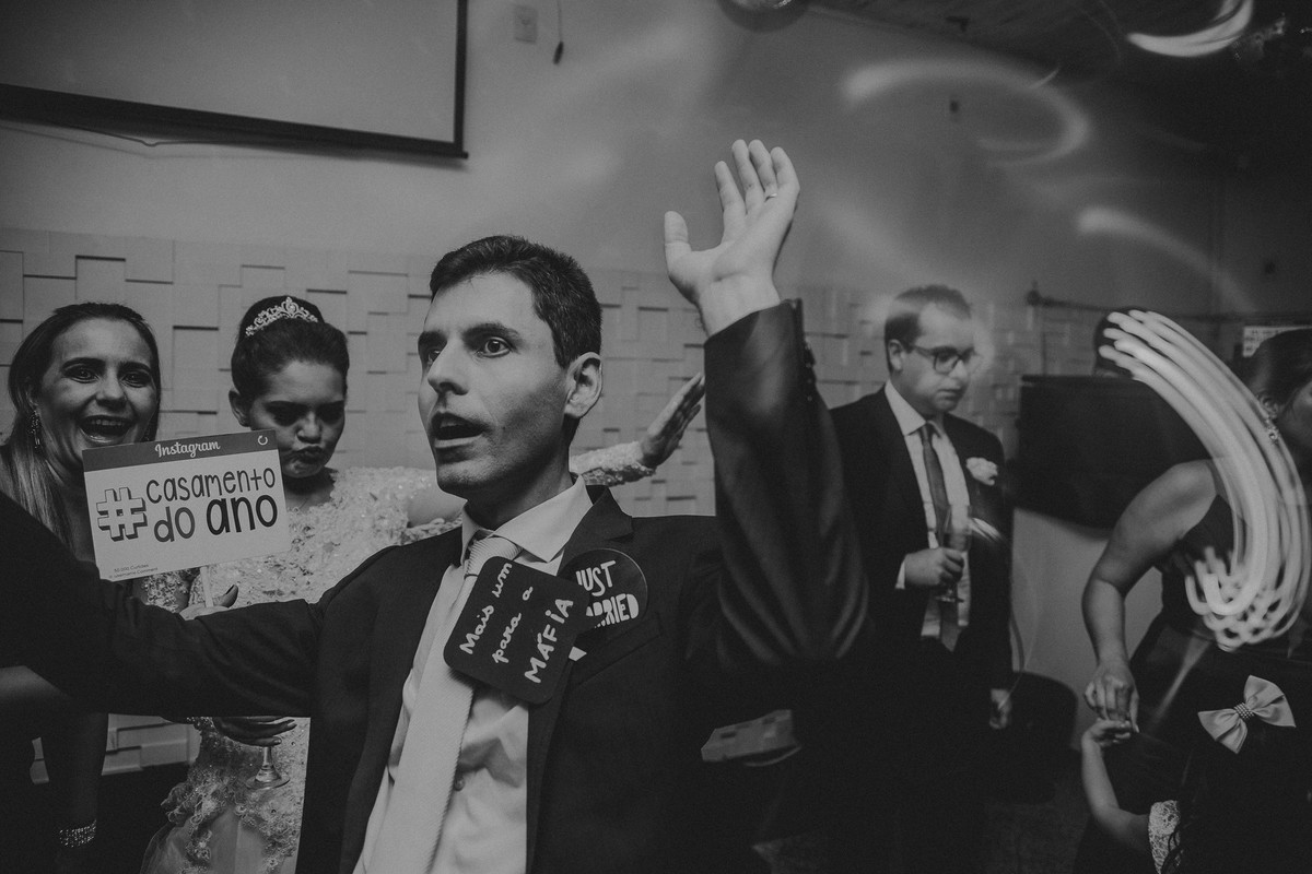 Fotografia divertida de casamento em que o noivo esta se divertindo na recepção