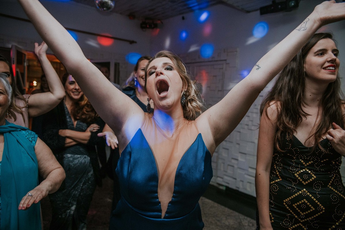 recepção de casamento em que a amiga da noiva está sorrindo e dançando