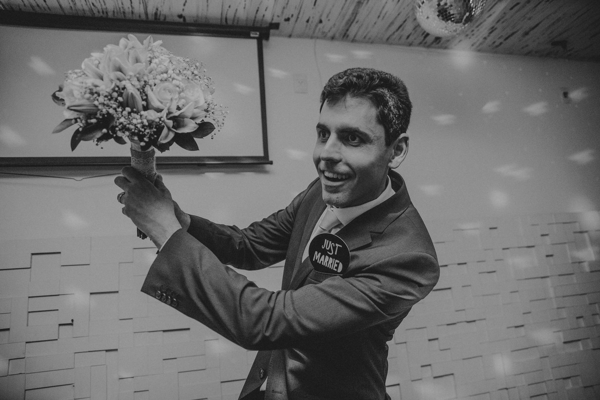 Noivo jogando o buque de casamento durante a recepção no Minas Tenis Clube