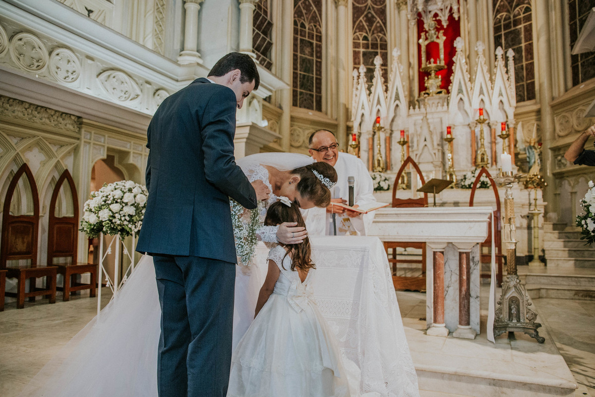 noivos recebendo as alianças em uma armação de coração