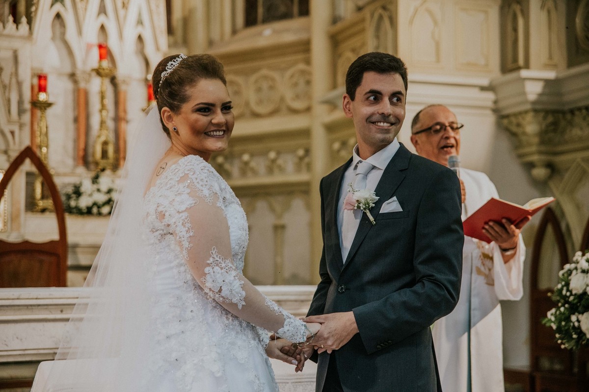 noivos sorrindo no altar ao verem seus convidados