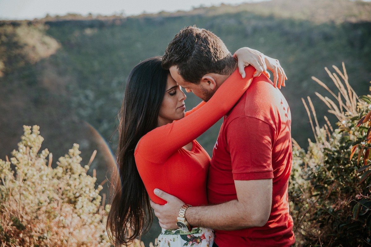 noivos abraçados no alto da montanha no por do sol
