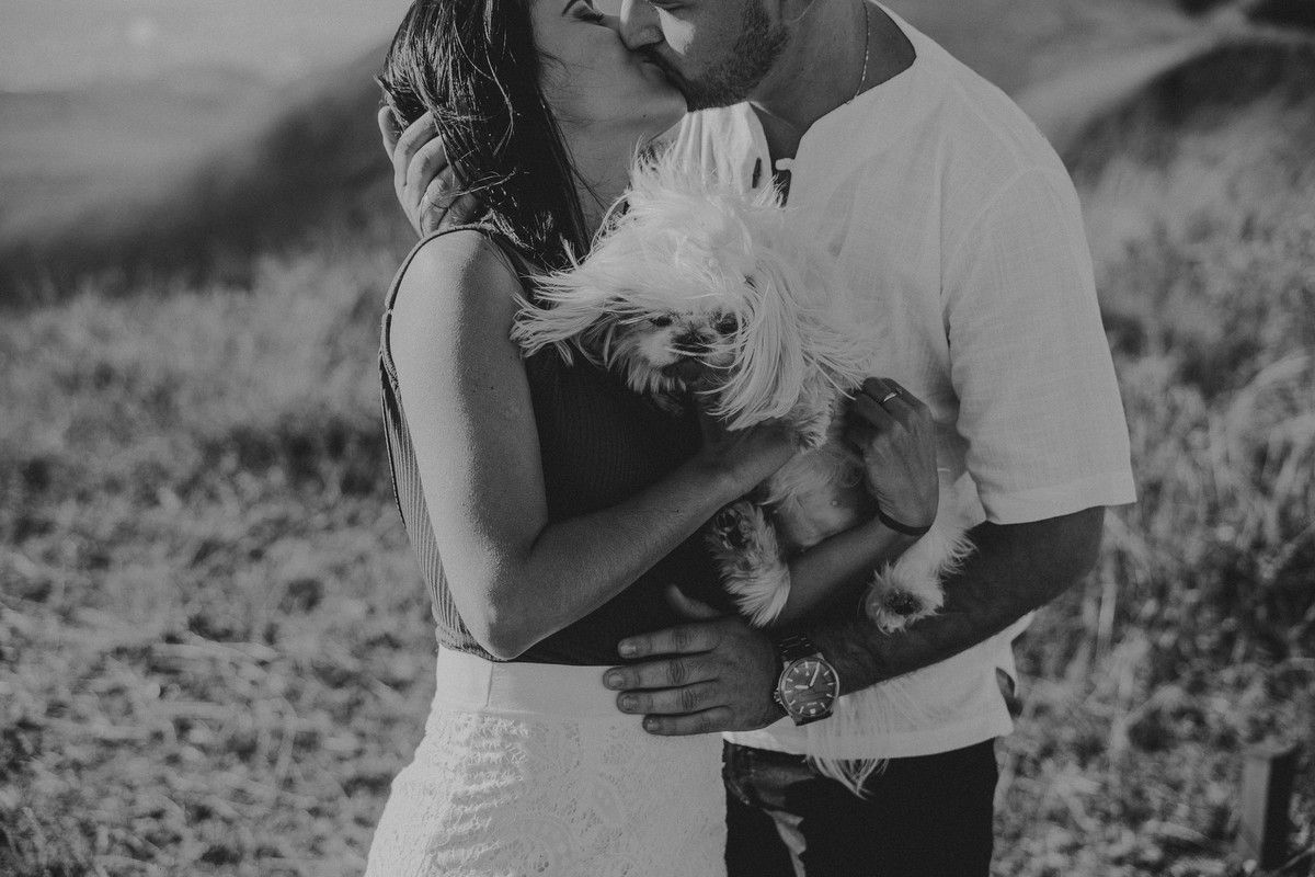 Noivos se beijando em um ensaio de pré casamento na serra do rola moça com animais de estimação