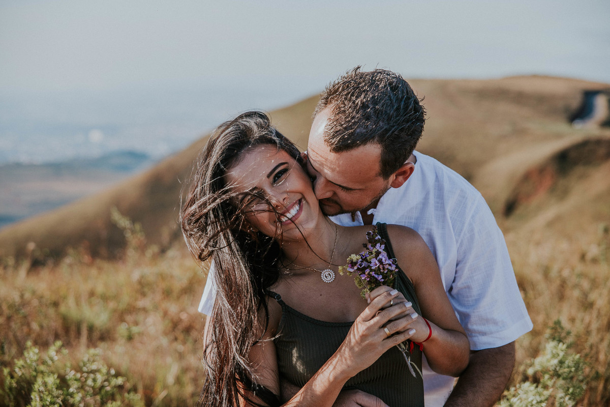 ensaio de casal na serra do rola moça belo horizonte o casal esta sorrindo e com vento nos cabelos