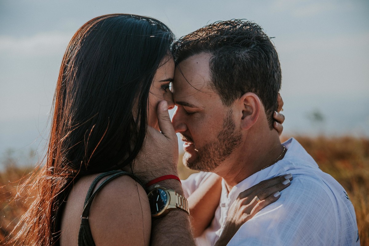 Noivos bem juntinhos e quase se beijando em uma foto criativa de pré casamento na serra do Rola moça