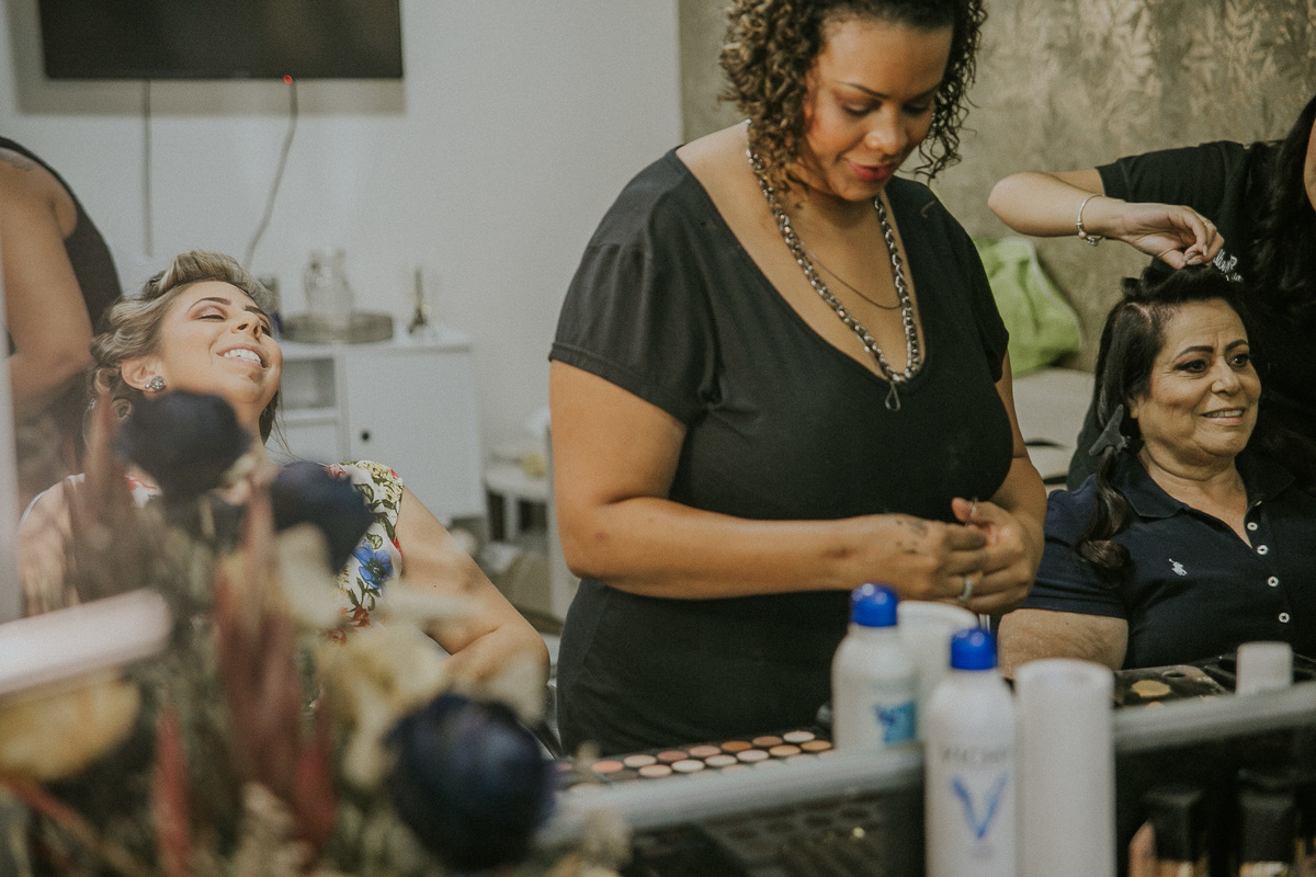 Mãe e irmã da noiva no making of arrumando cabelo e fazendo makeup