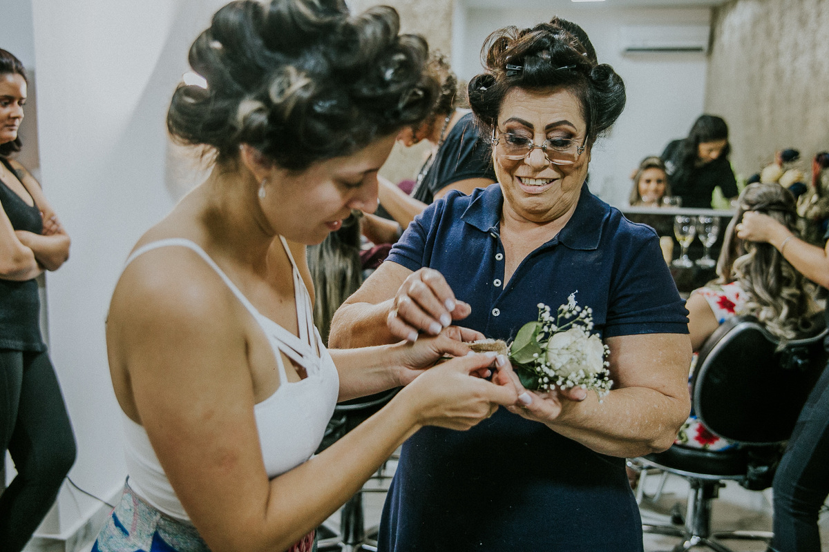 Mãe da noiva ajudando a noiva a terminar a decoração feita a mão para o casamento