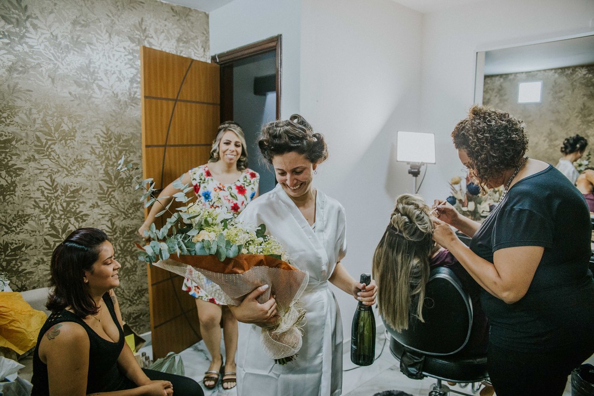 Noiva sorrindo ao receber um buque de presente do pai como surpresa