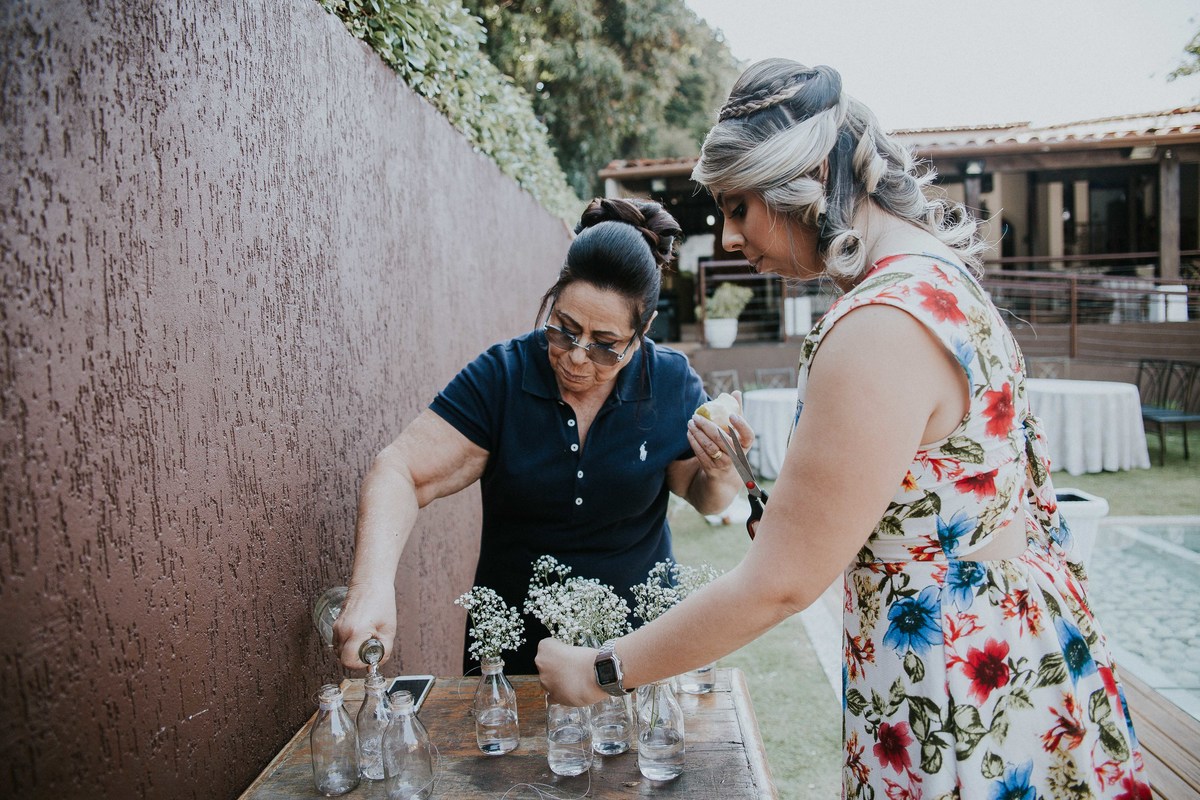 Mãe da noiva e irma da noiva arrumando a decoração para o casamento n casa orla