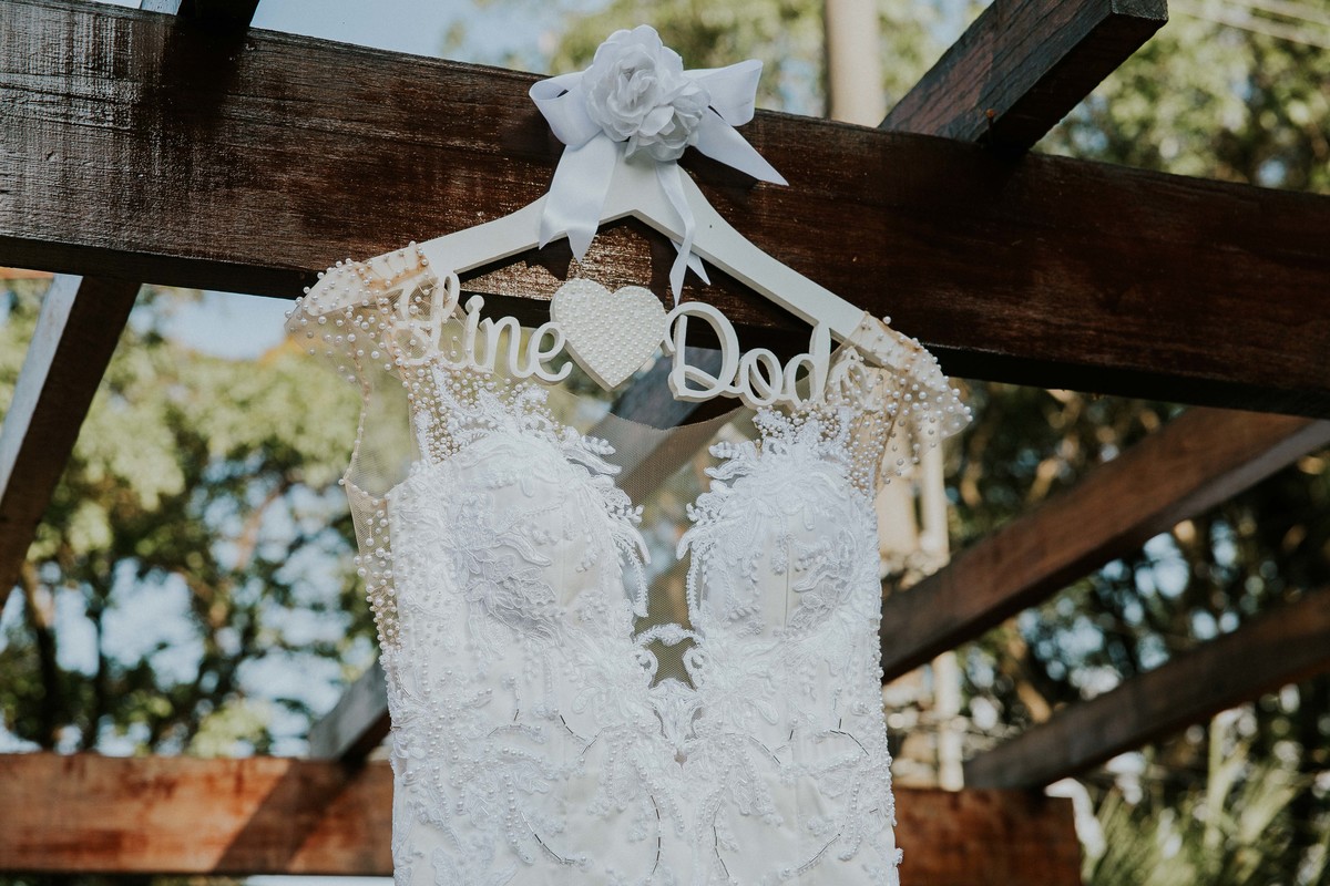 Detalhe do vestido da noiva pendurado no altar do casamento