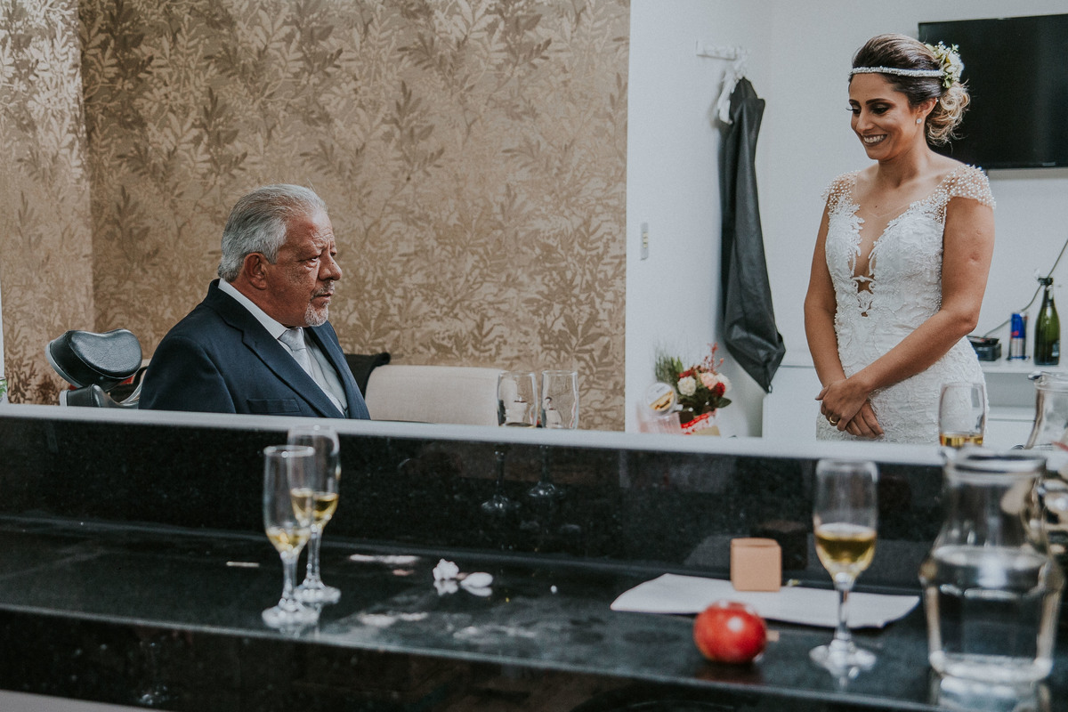 noiva olhando para o pai emocionado ao ver a filha pela primeira vez vestida de noiva