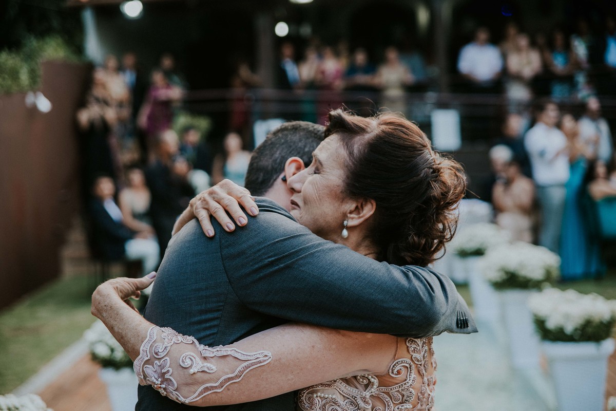 mãe abraçando o filho ao entrega-lo para o casamento e se emociona