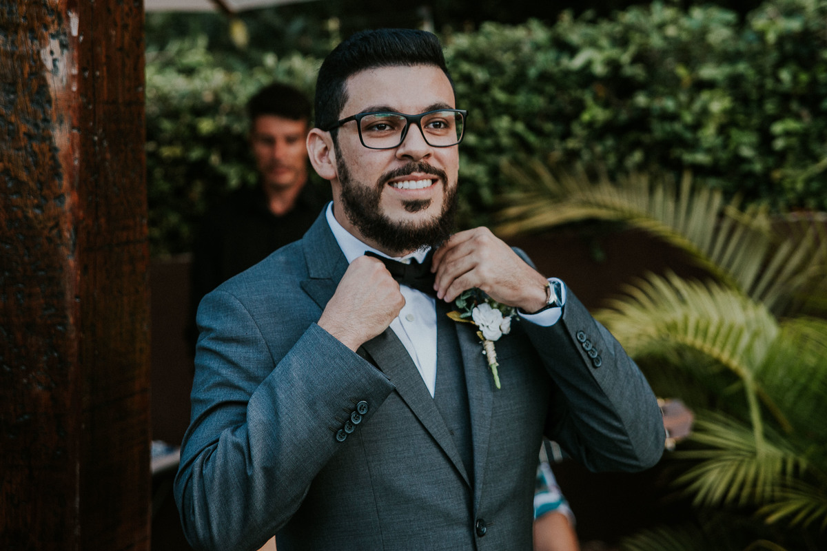 Noivo arrumando a gravata ao ver a noiva entrando 