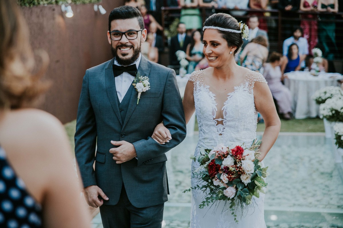 Noivos sorrindo ao estarem caminhando para o inicio da cerimonia de casamento em Belo Horizonte