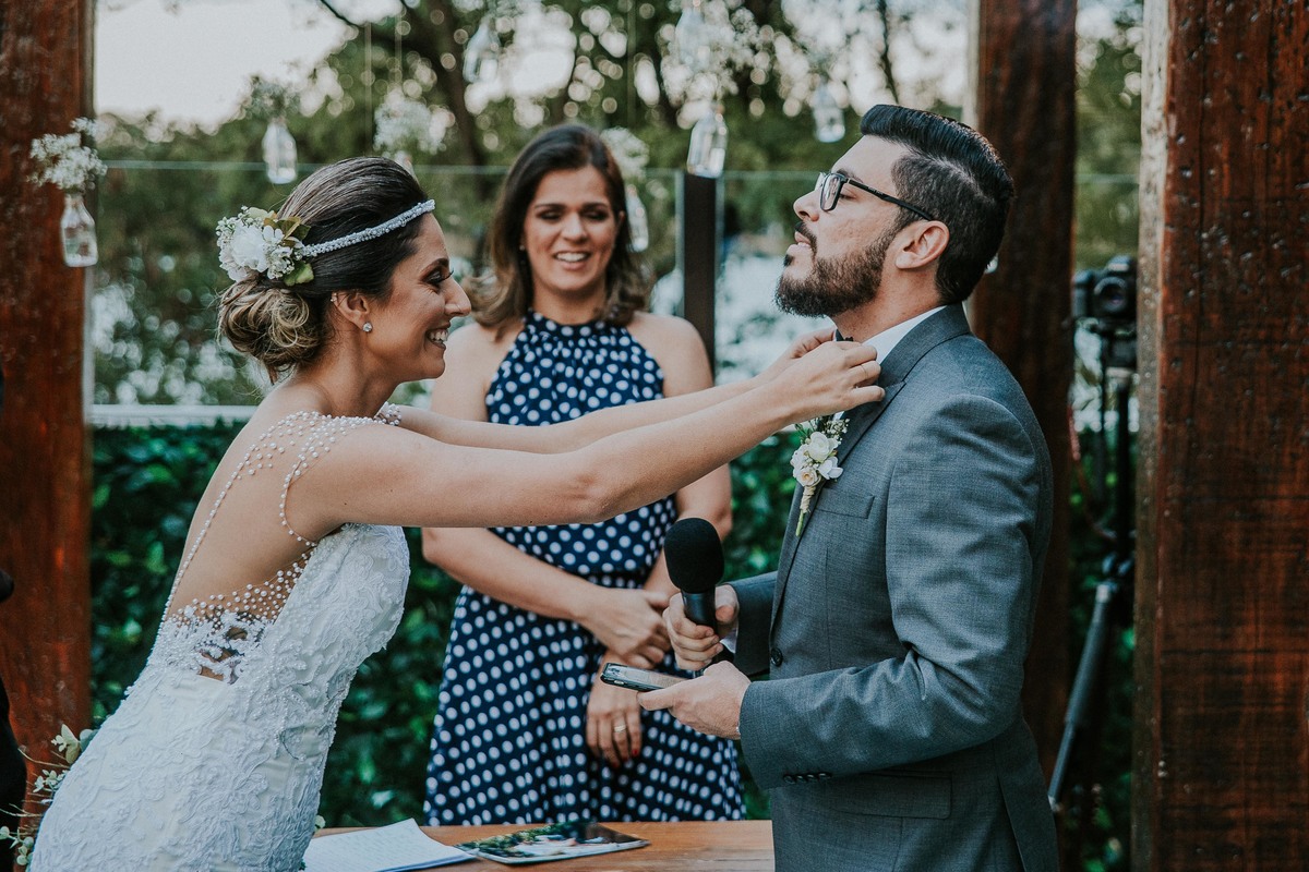 fotografia de casamento criativa em que a noiva esta ajudando o noivo com a gravata