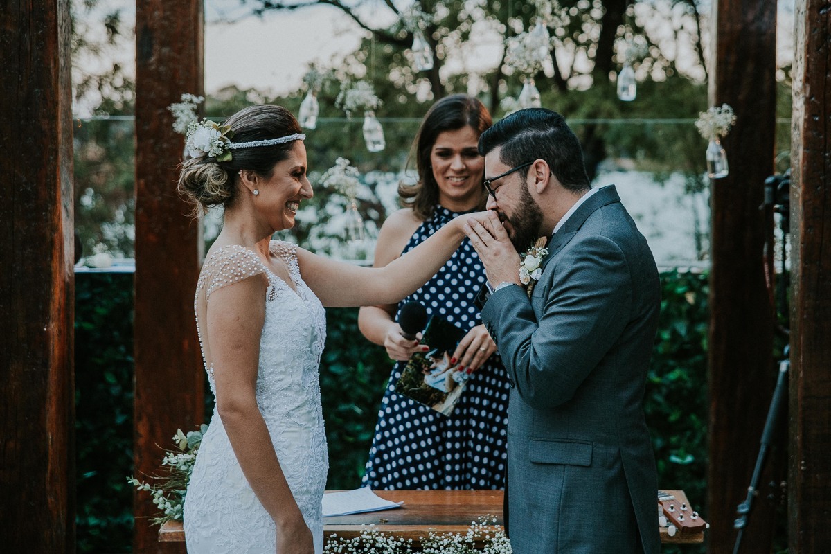 noivo beijando a mão da noiva durante a troca de alianças em BH