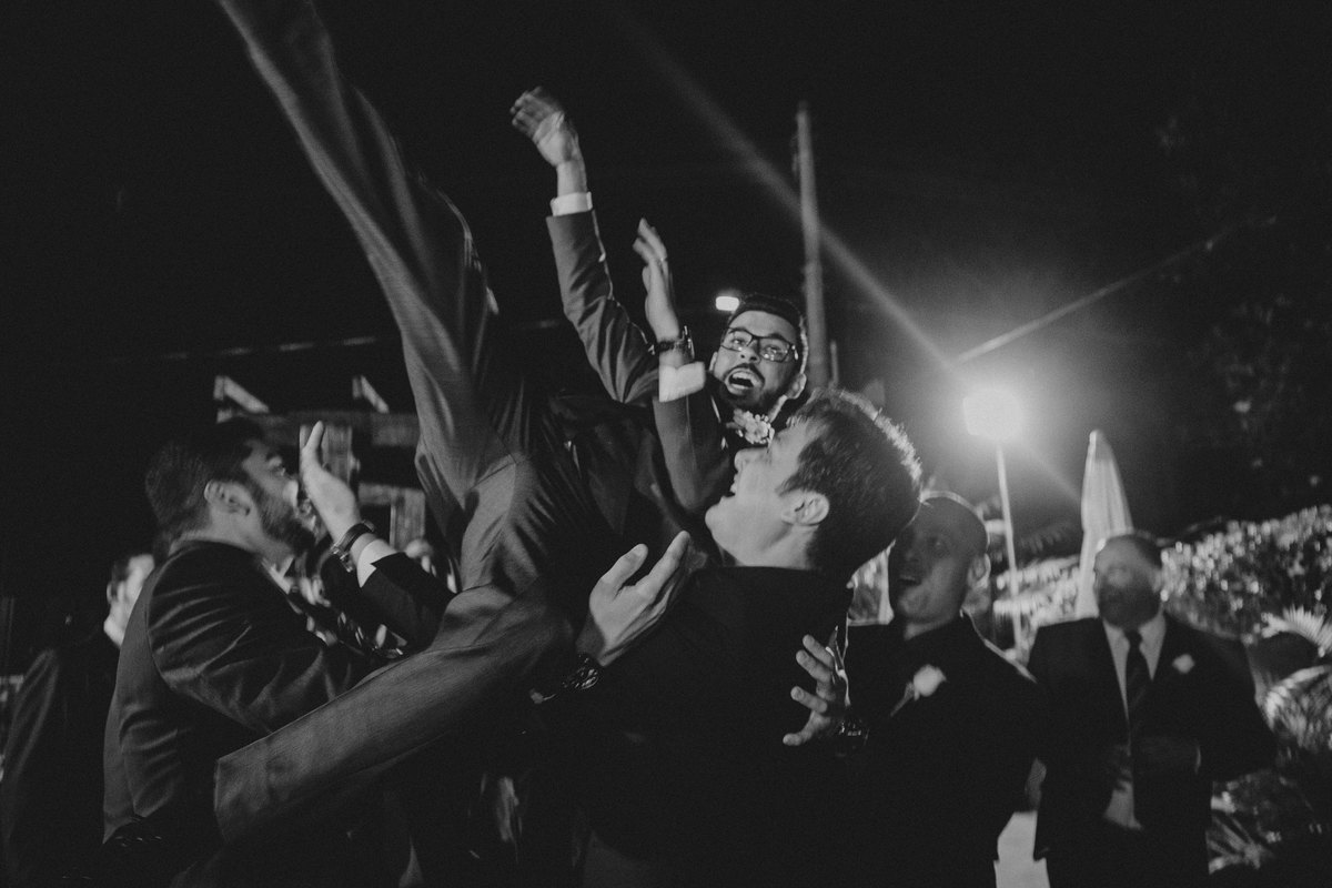 padrinhos jogando o noivo para o alto durante a recepção de casamento em BH