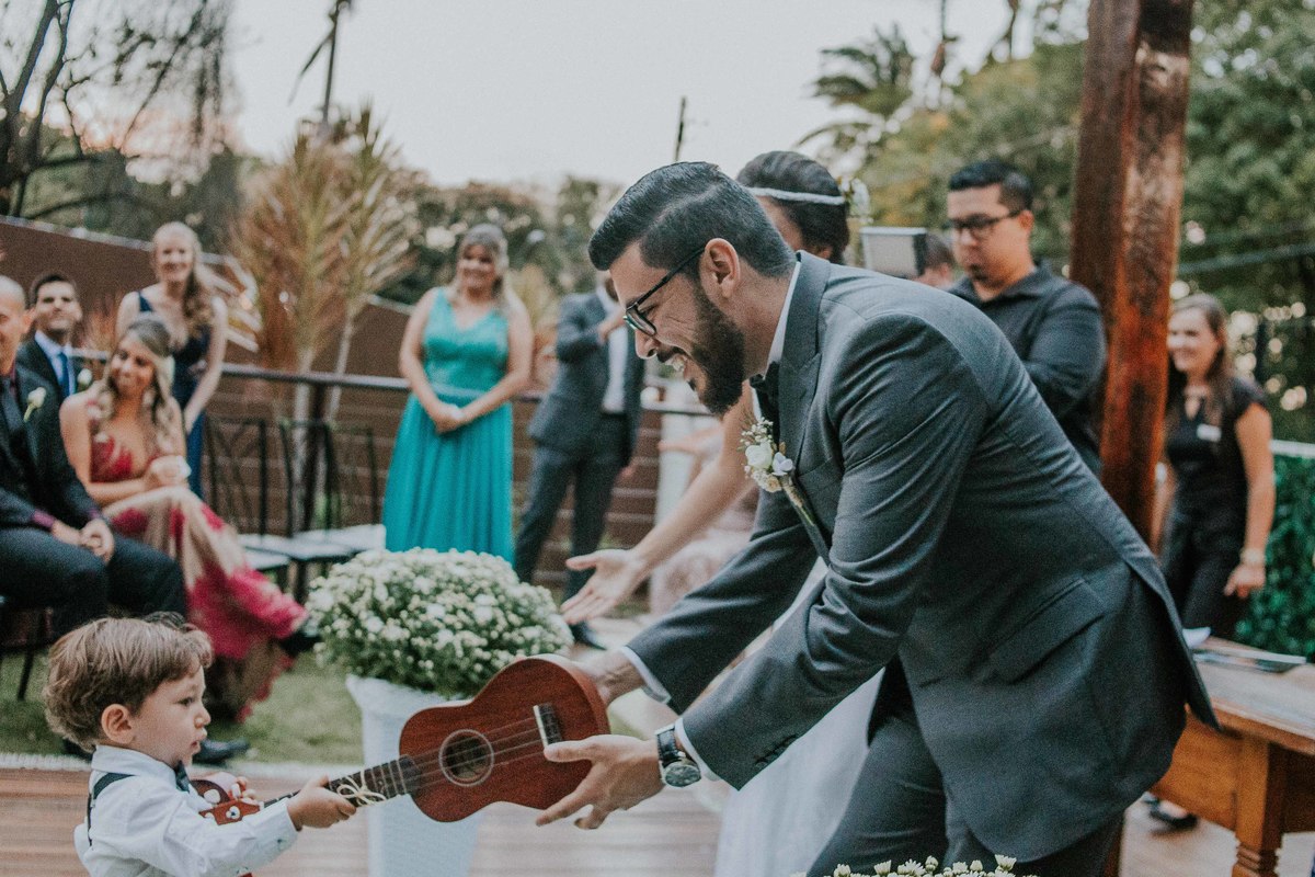 Noivo recebendo as alianças em um ukulele do pagem