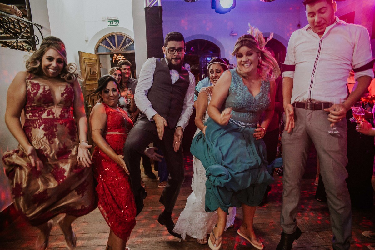 Noivos e convidados dando sarrada no ar durante a recepção do casamento