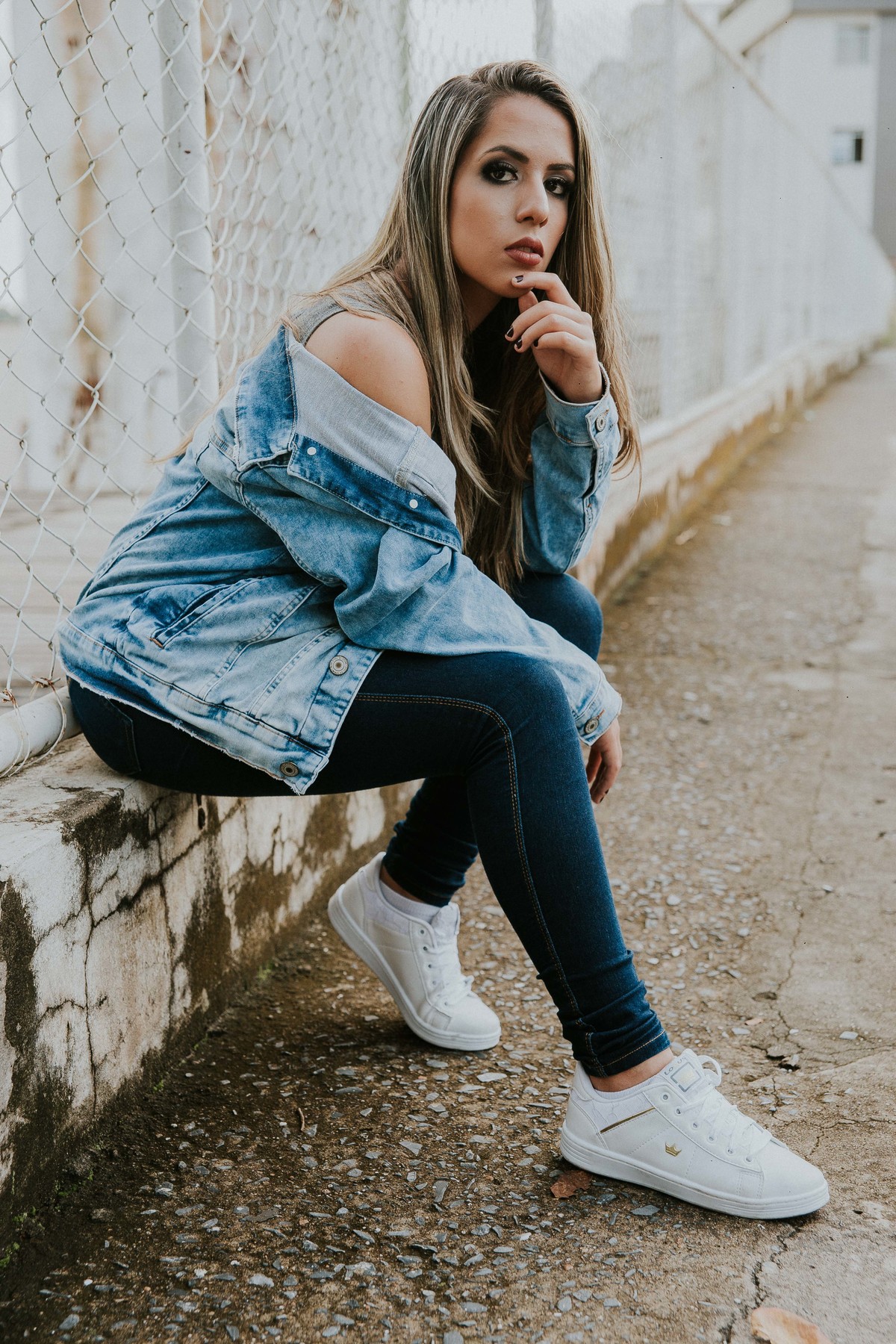 poses criativas para ensaio feminino no qual a modelo está sentada e olhando para a camera