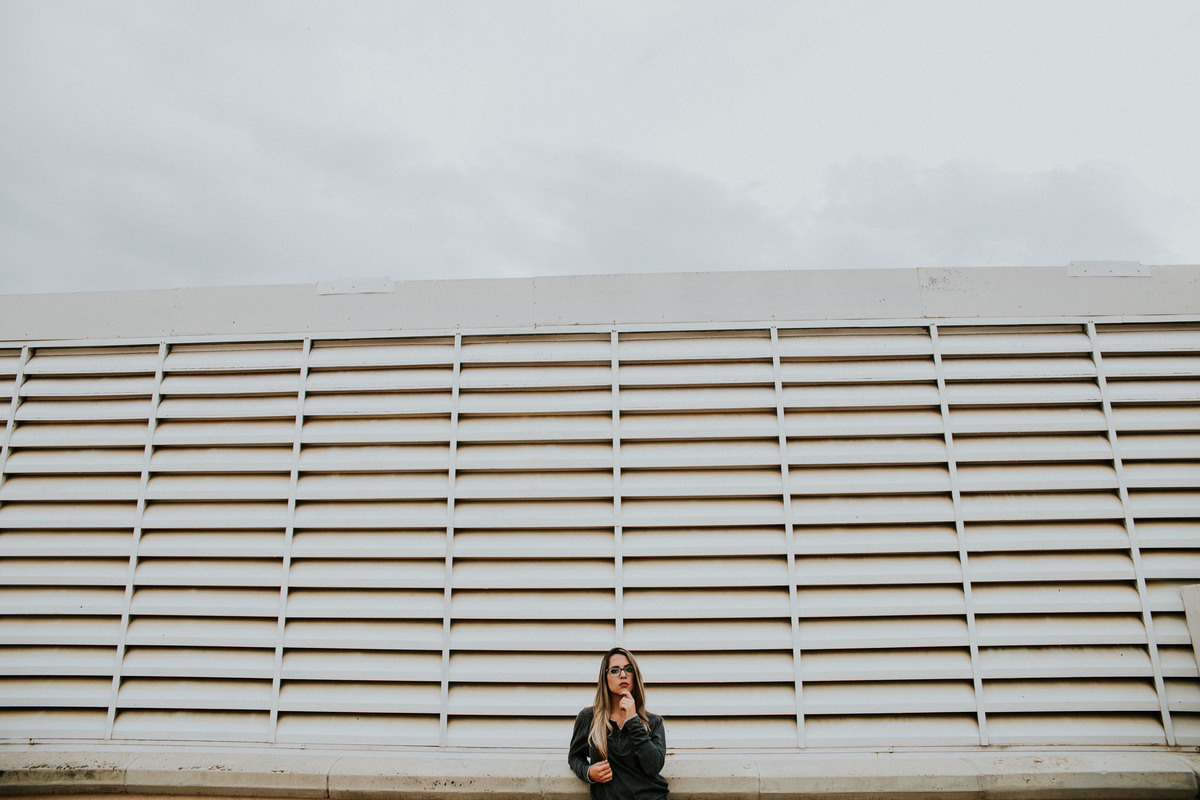 ensaio feminino de 15 anos no qual a modelo está olhando para o fotografo em um ensaio no estacionamento