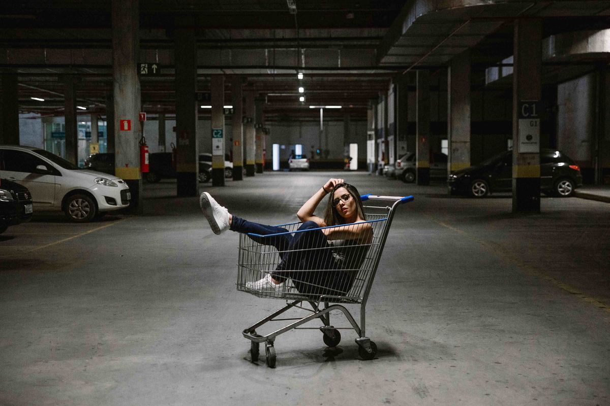 ensaio feminino criativo no qual a modelo esta dentro de um carrinho de supermercado em betim