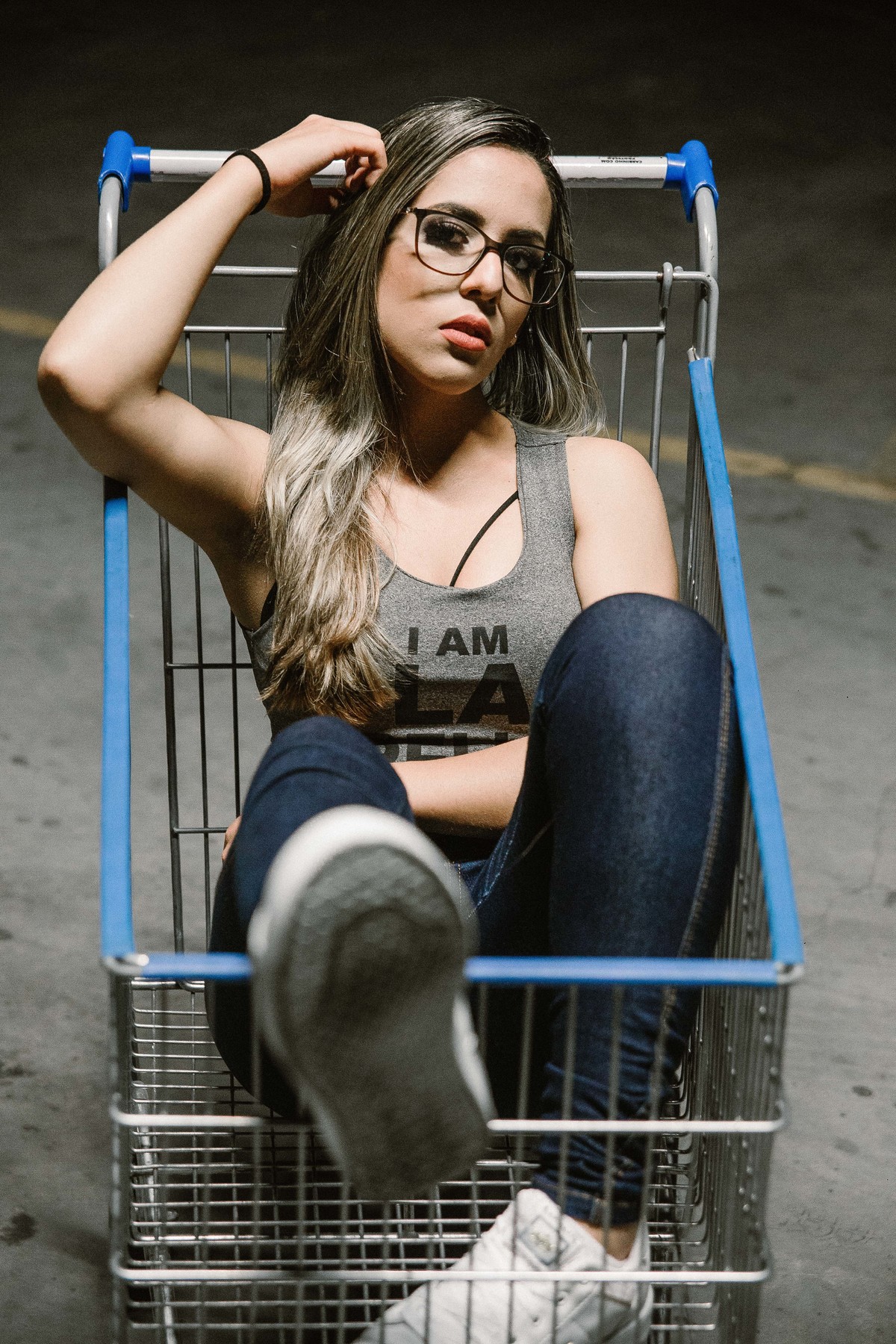 ensaio feminino no qual a modelo está dentro do carrinho de supermercado em uma foto criativa de ensaio steet