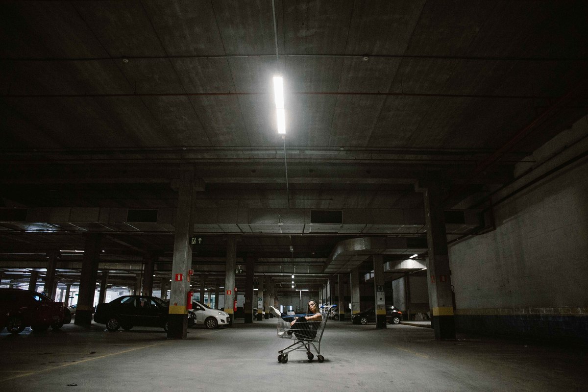 fotografo de ensaio feminino no qual a modelo está dentro de um carrinho de supermercado