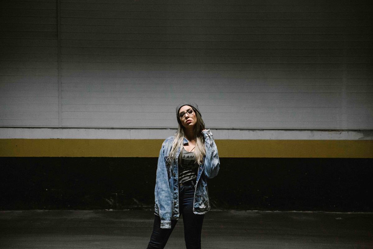 fotografia de ensaios femininos em betim no qual a modelo está olhando para a camera em um ensaio no estacionamento do shopping