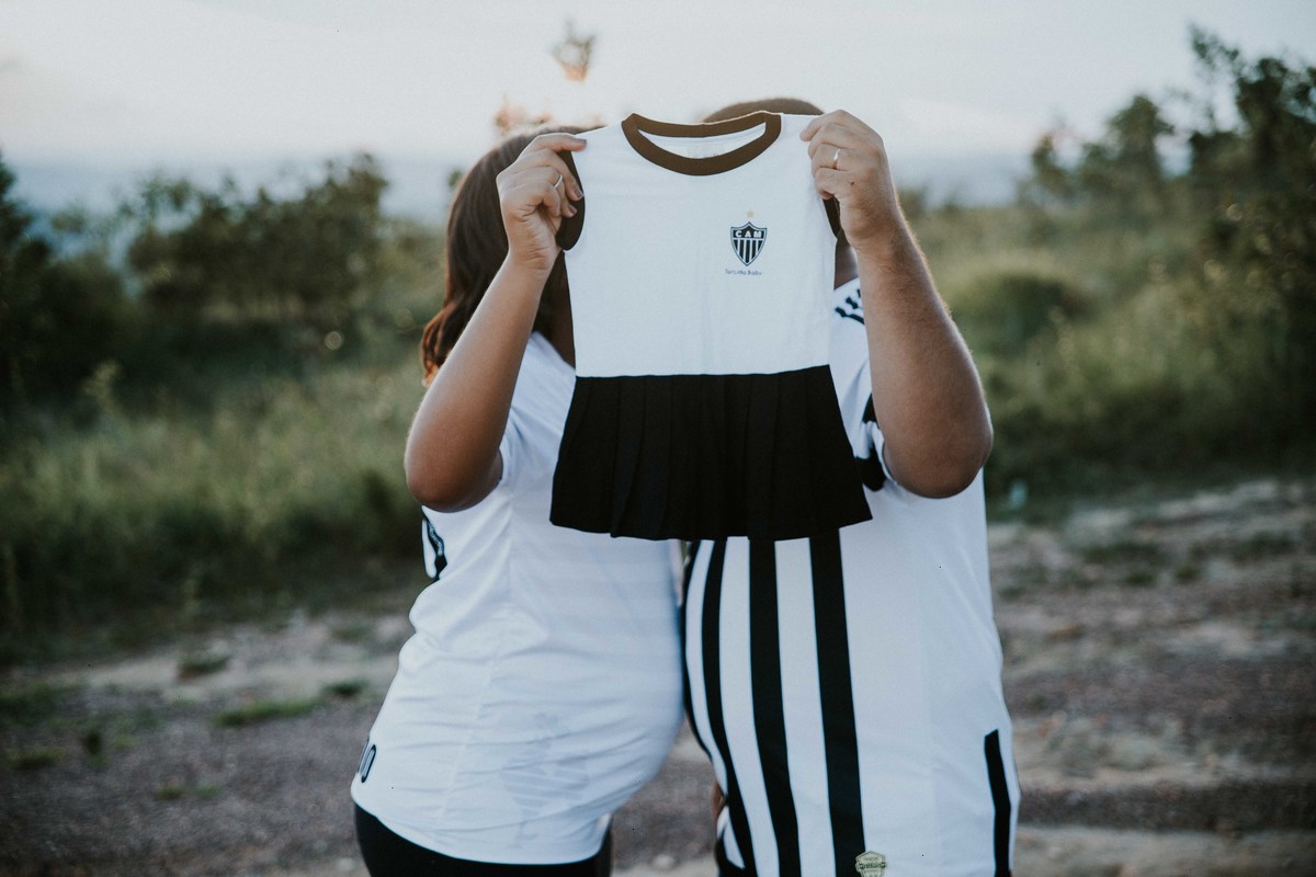 ensaio de gestante criativo com tema de time no qual os pais estão usando a Camisa do Atlético Mineiro
