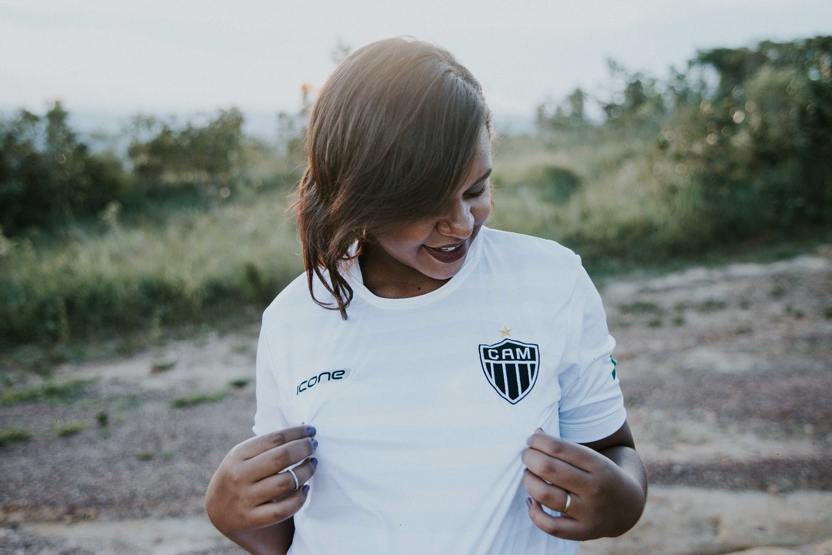 Ensaio de gestante com tema de futebol no qual a gestante está usando a camisa do Atlético Mineiro