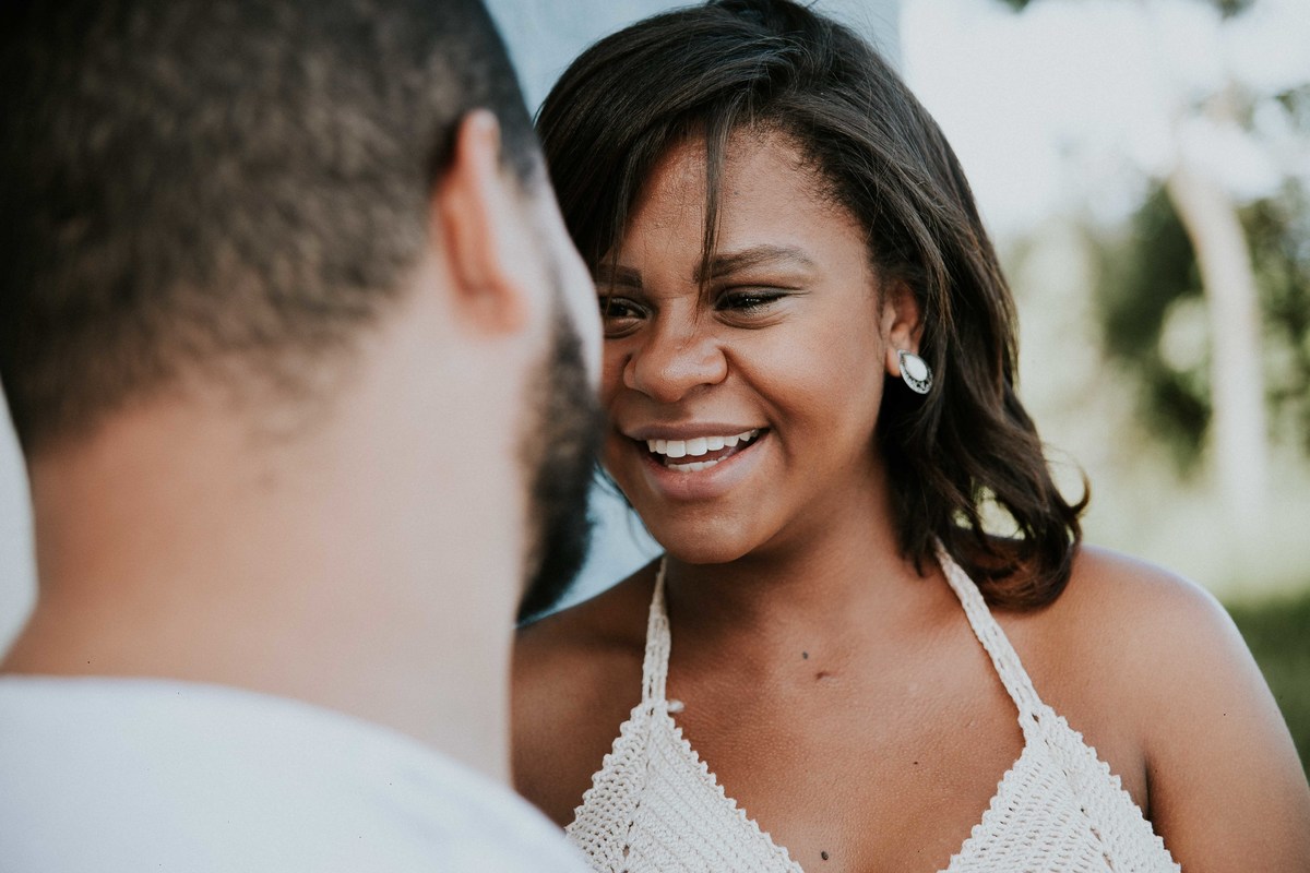 ensaio de gestante no qual a mãe está olhando para o pai e sorrindo 