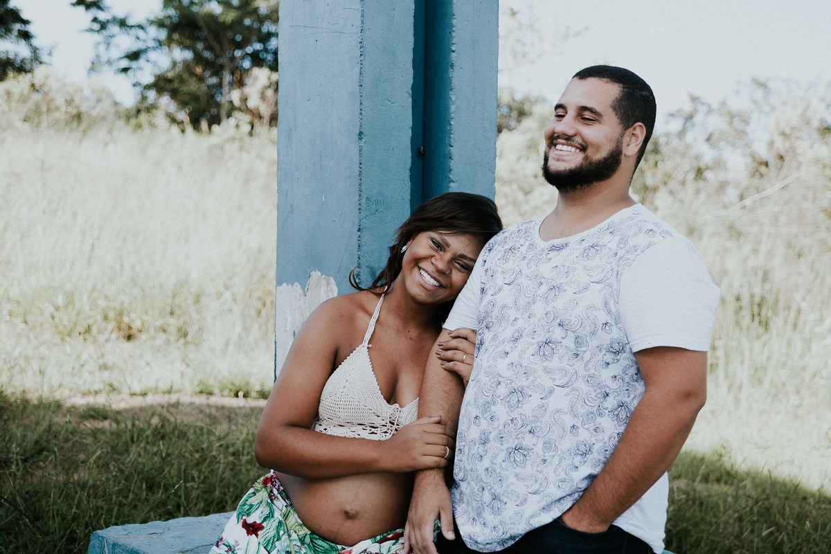 ensaio de gestante em Mateus Leme no qual os pais estão abraçados e sorrindo