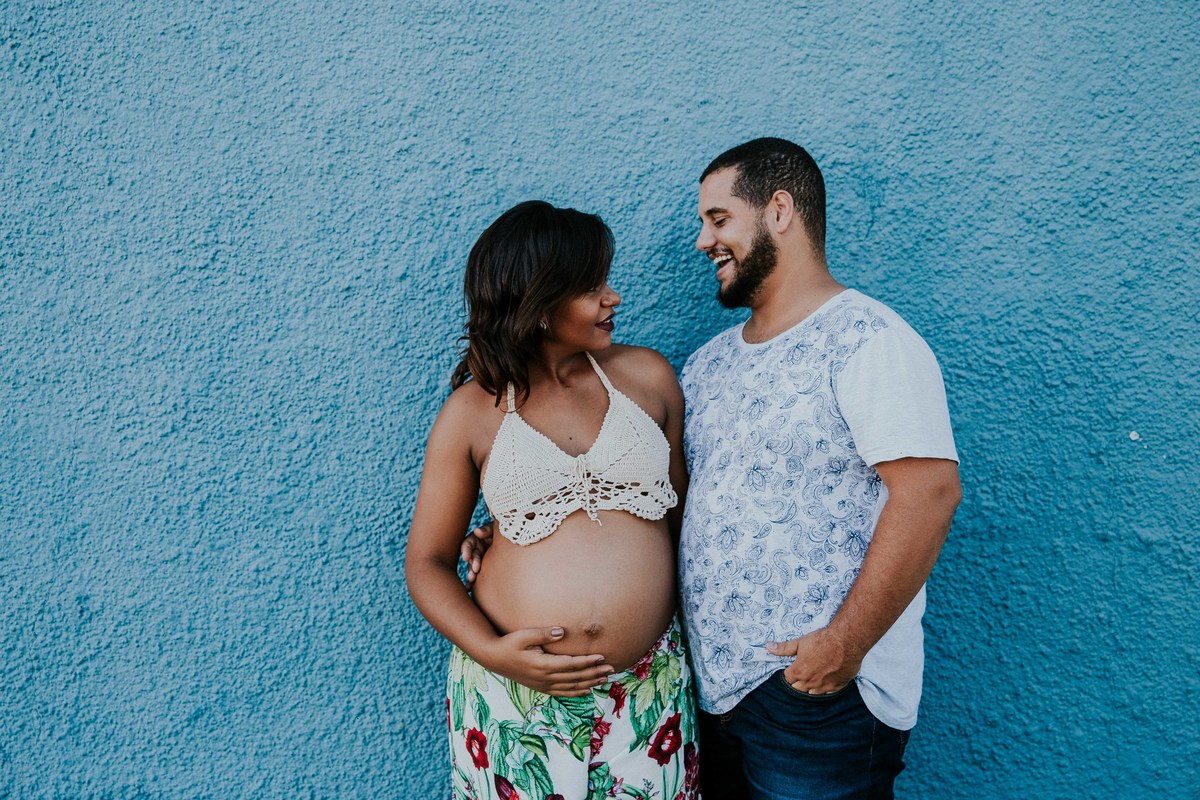 fotografia criativa de ensaio de gestante no qual os pais estão sorrindo