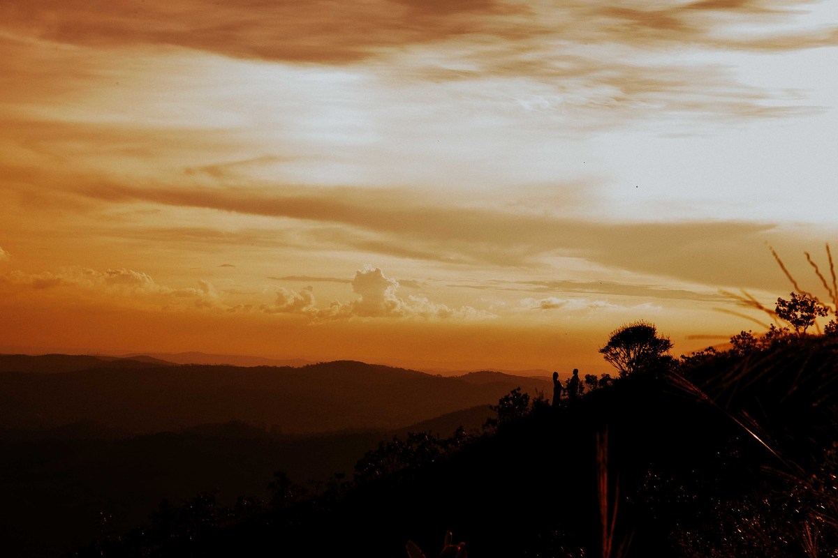 fotografia criativa de gestante feita no por do sol e no alto da montanha 