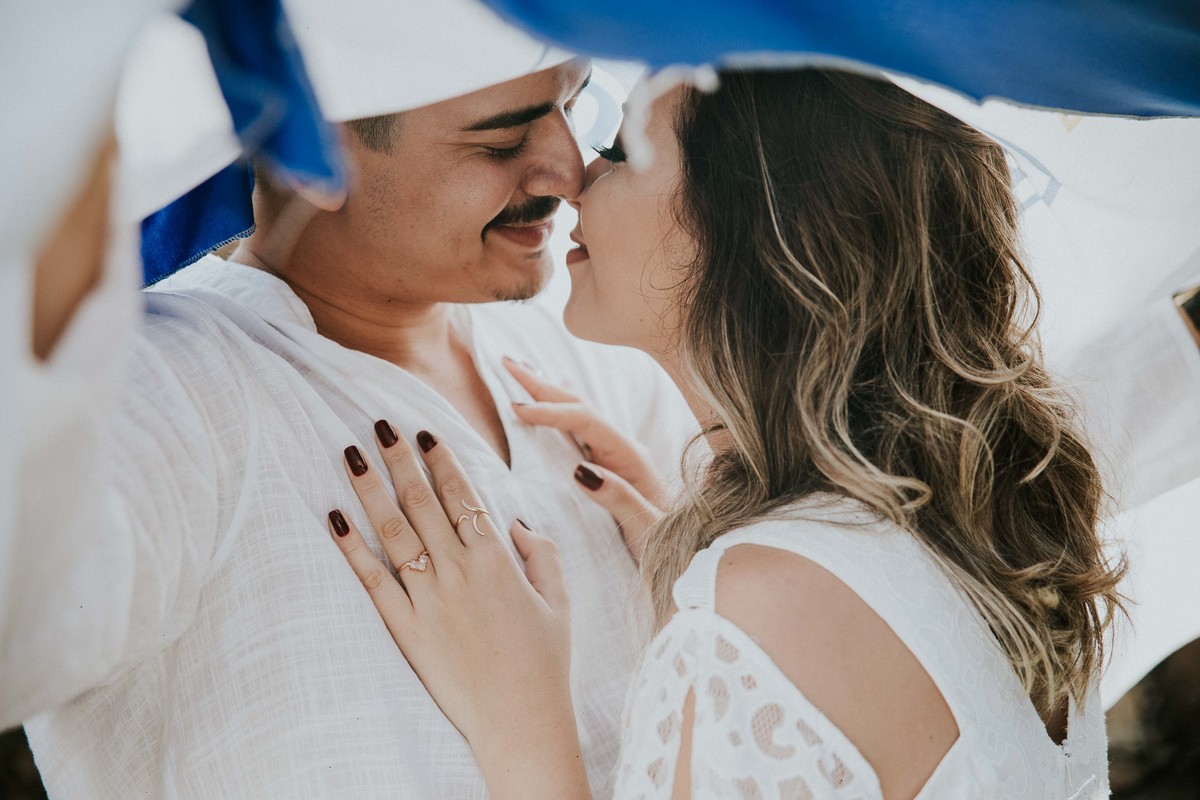 ensaio de pré casamento com a temática de time no qual estão cobertos com a bandeira do cruzeiro